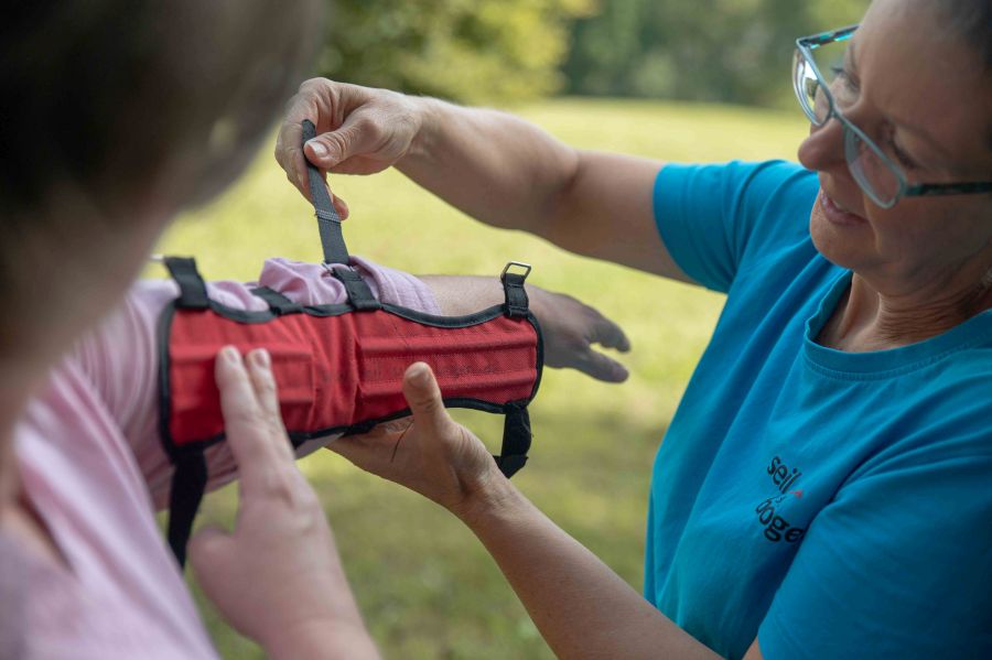 zwei Frauen beim Anlegen eines Armschutzes